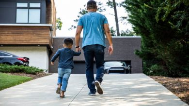 Father walking up driveway with son