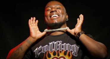 A man with a t - shirt on and a necklace.