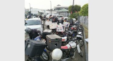 Scooters and motorcycles parked outside a commercial area in Alberton, South Africa.