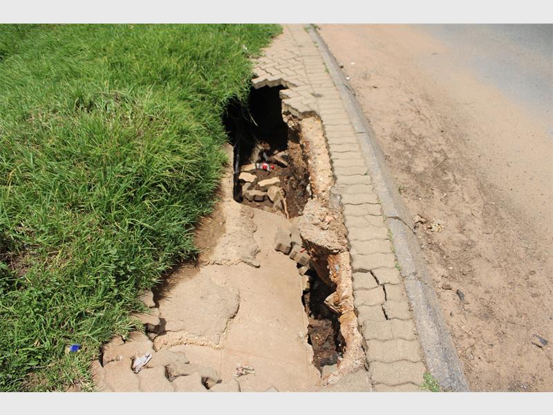 The damaged sidewalk poses a serious hazard to the public.