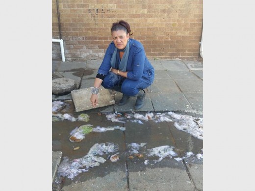 NOT WORKING: DA Ward 57 Councillor Faeeza Chame next to one of the overflowing drains in Millwood Court in South Hills. Residents can contact Clr Chame on 082 518 4375 or e-mail faychame@hotmail.com for assistance.