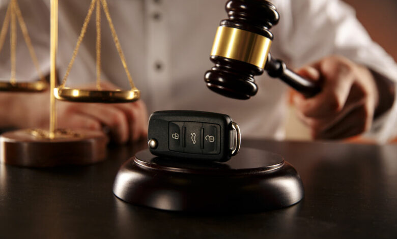 Close up of judge gavel and car keys over soundboard on white