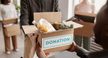 volunteer-collecting-donation-box-from-another-volunteer_23-2149230544