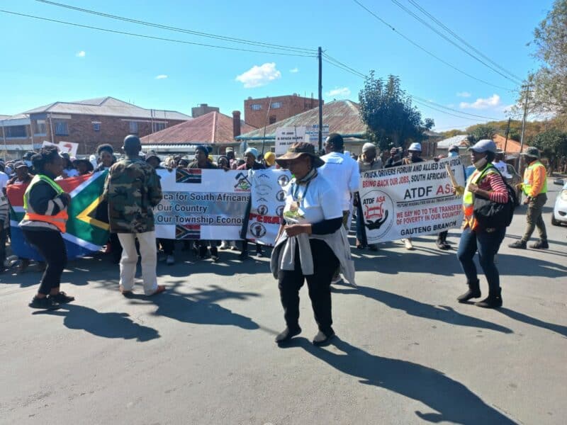 Marchers demand arrests and disconnections as police block access to a building believed to be occupied by foreign nationals.