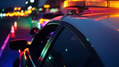 A police car stopping a vehicle at night.