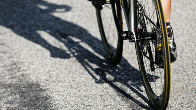 A close up view of a male professional road cyclist and his racing bicycle.