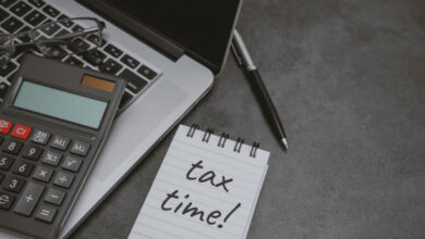 Tax Time written on notepad with laptop and calculator.