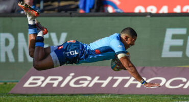 A rugby player dives to score a try.
