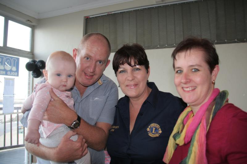 Emily Moffat and her parents James and Tammy are congratulated by fundraising chairman, Lion Mandy Roux.