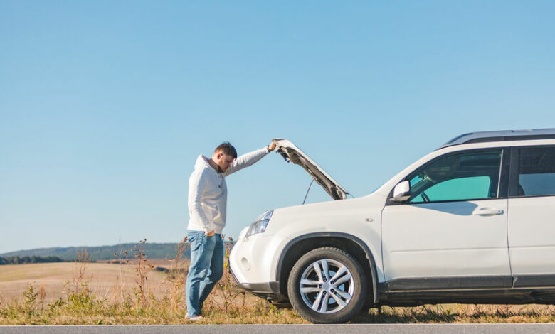 man standing near car with opened hood on sunset