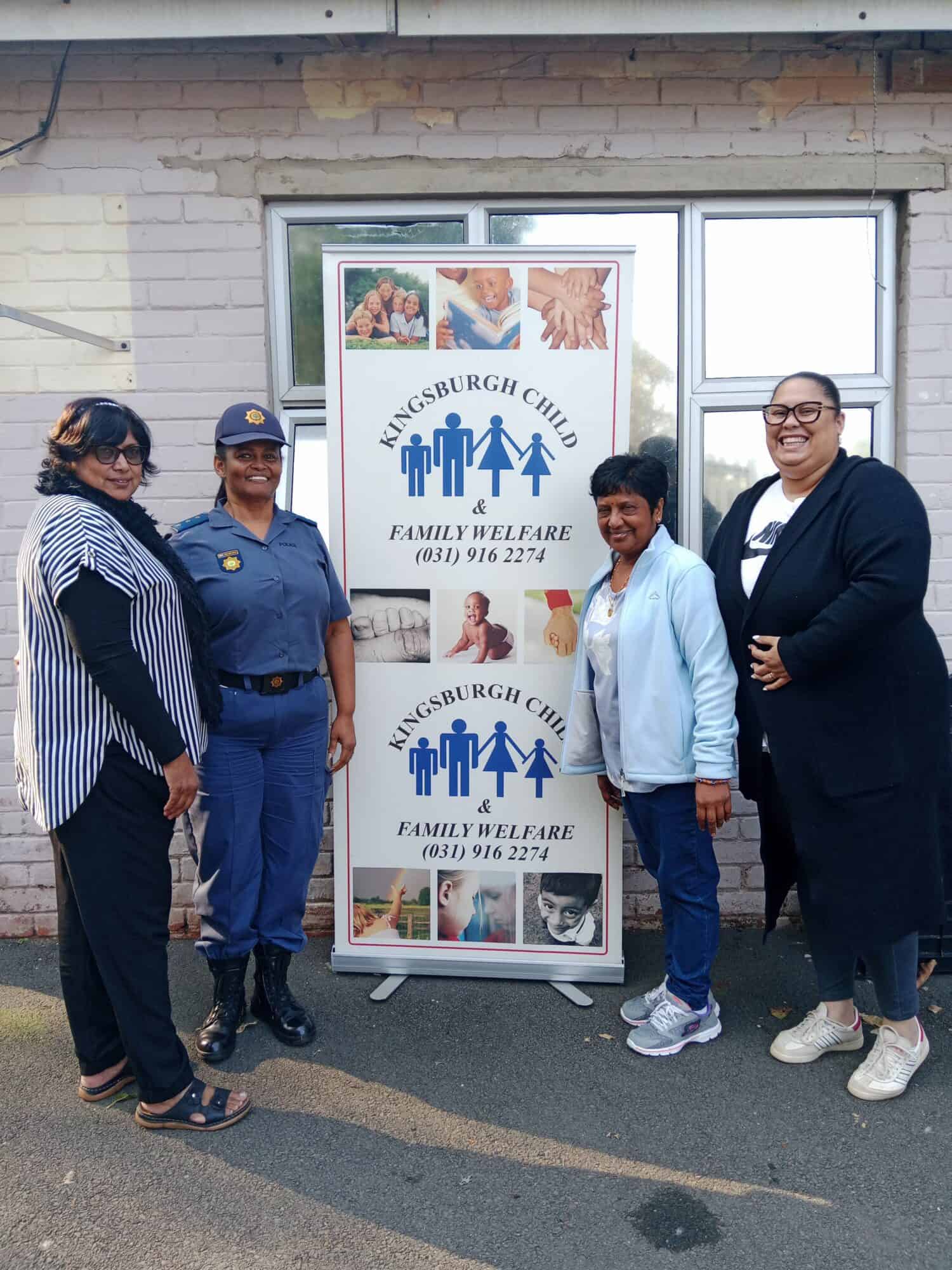 A group of four women in front of a banner. 