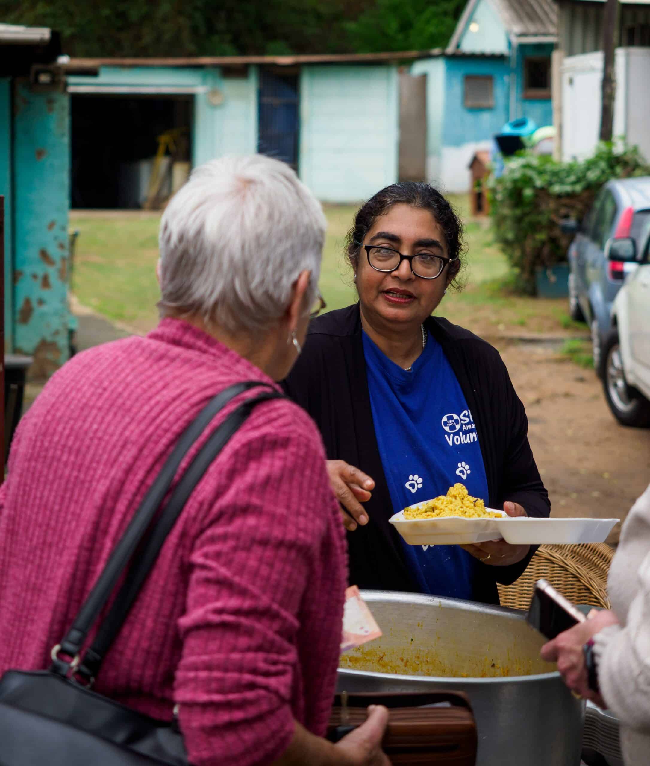 A woman serving an Indian rice dish.
