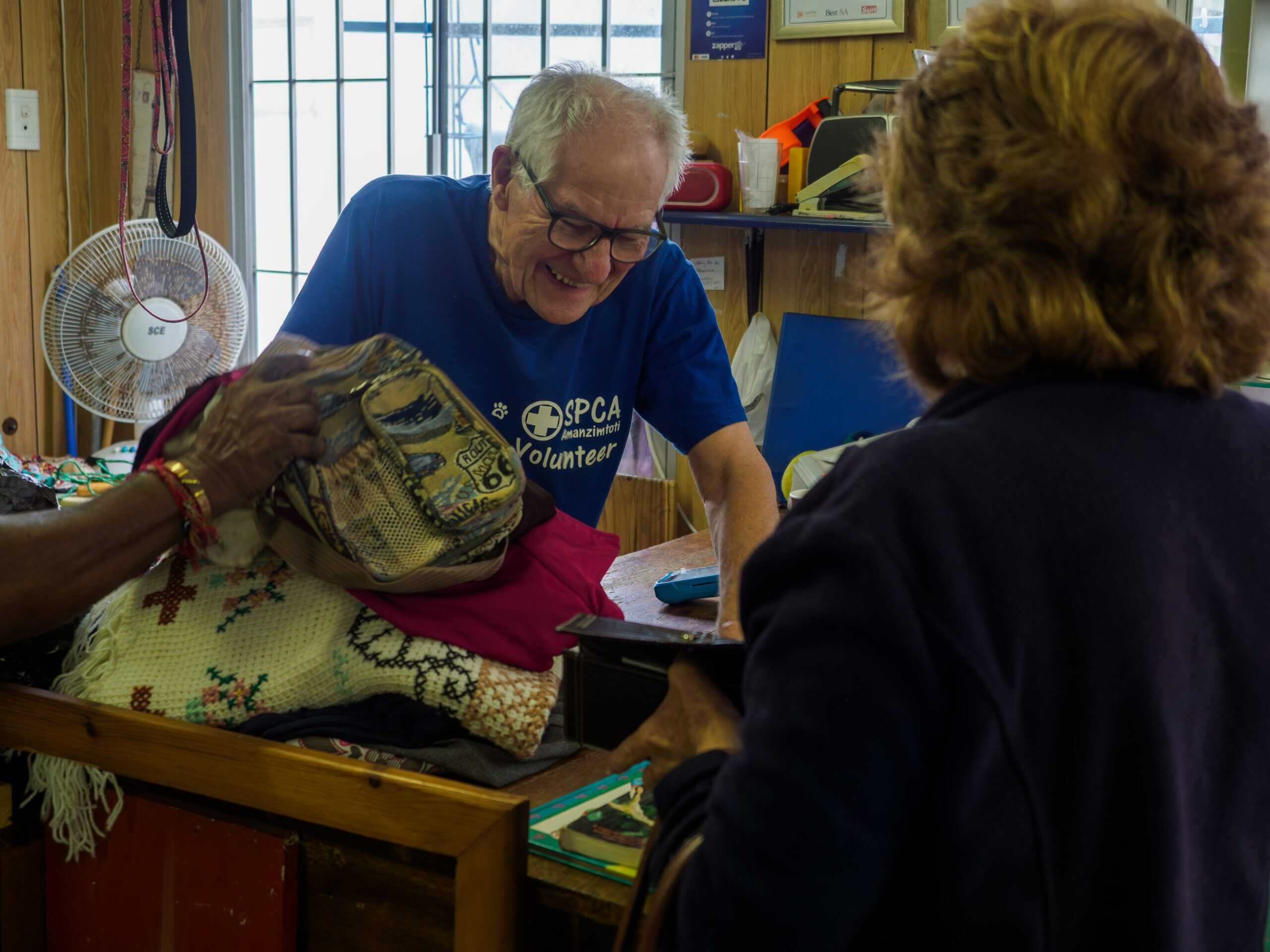 A man sells items at a thrift shop.
