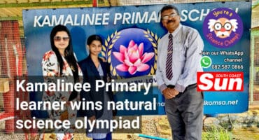 A teacher, learner and principal standing in front of the school banner.