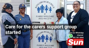 A group of four women in front of a banner.