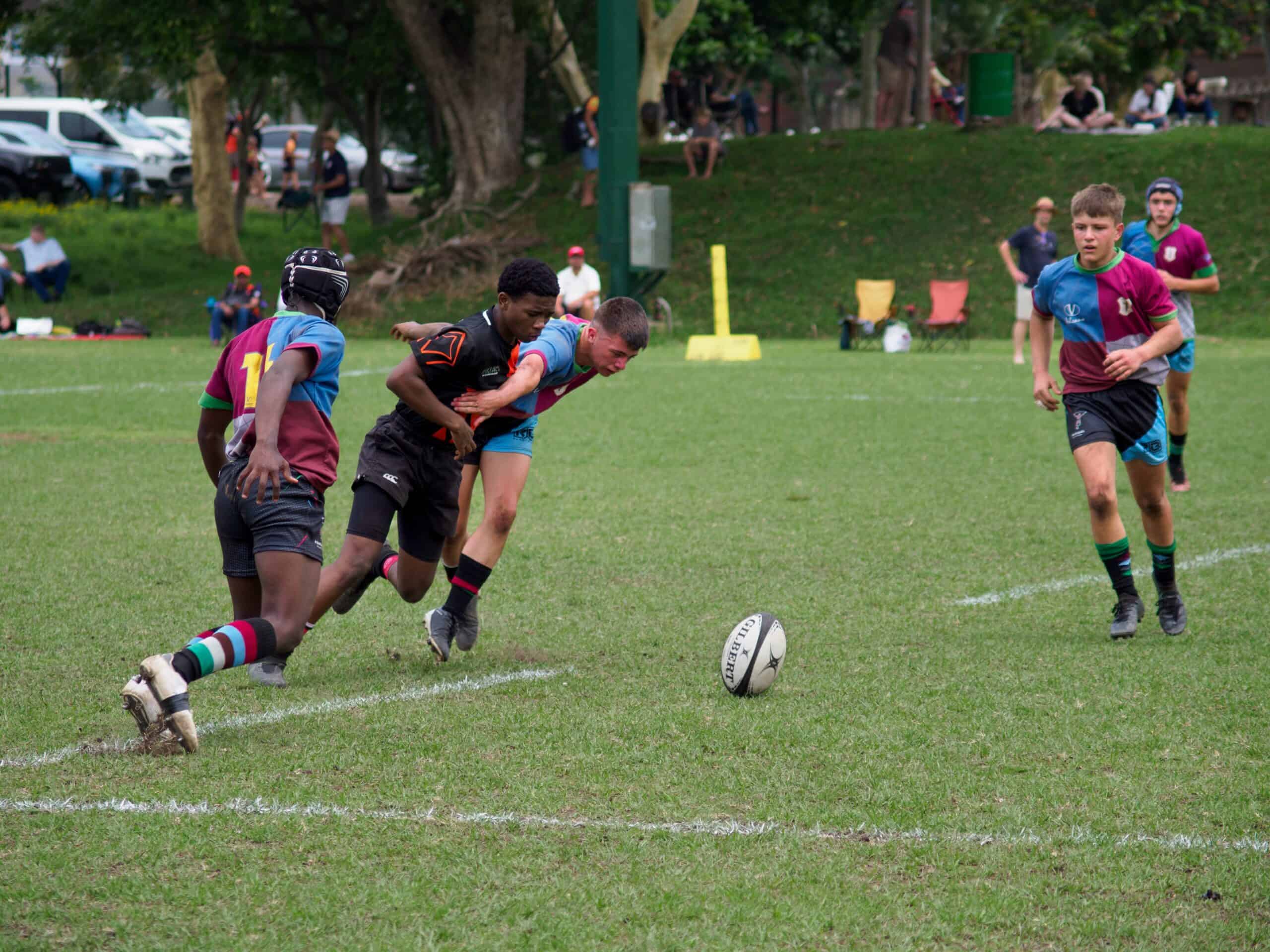 Two rugby players try to get the ball.