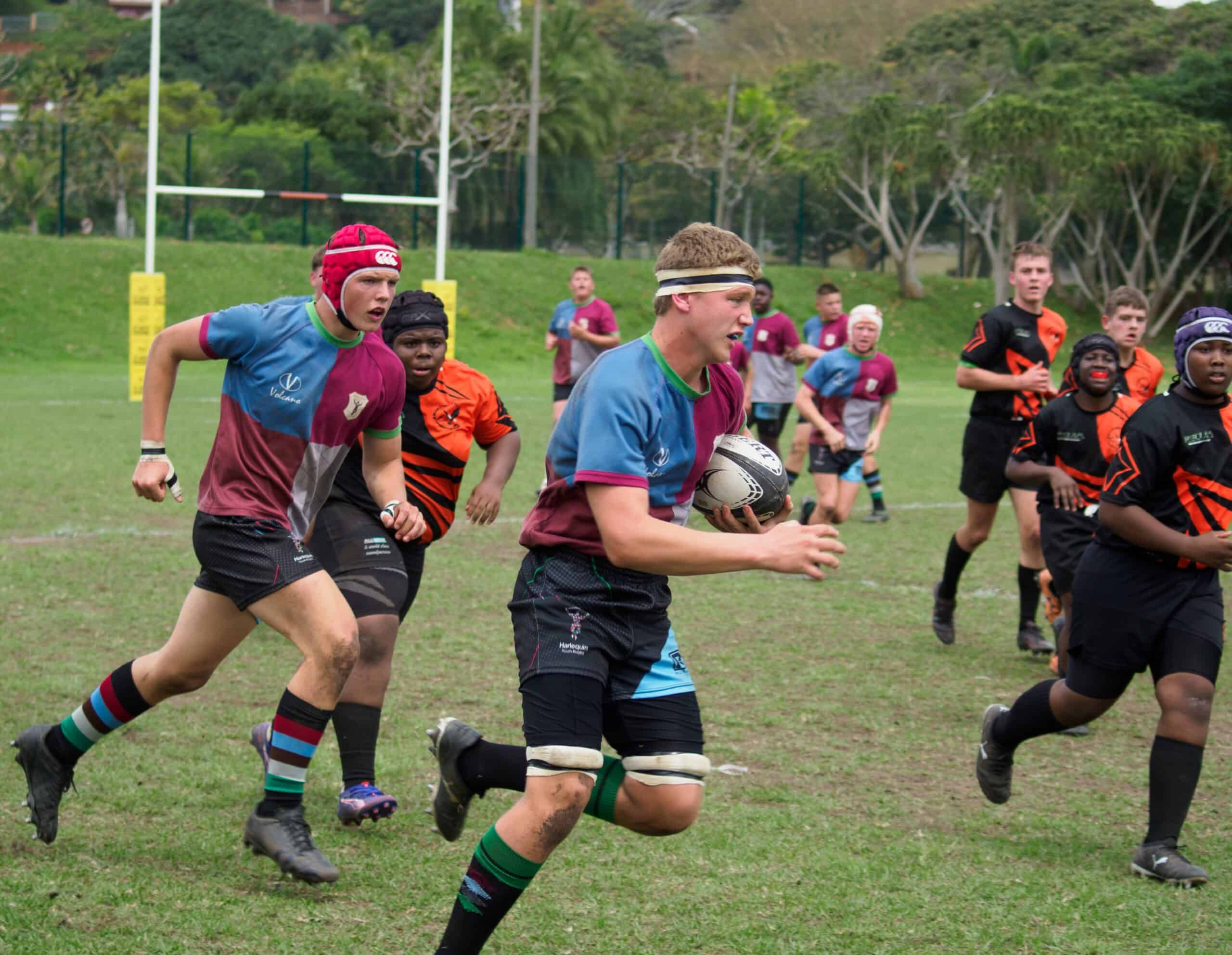A rugby player tries to make it past a defender.
