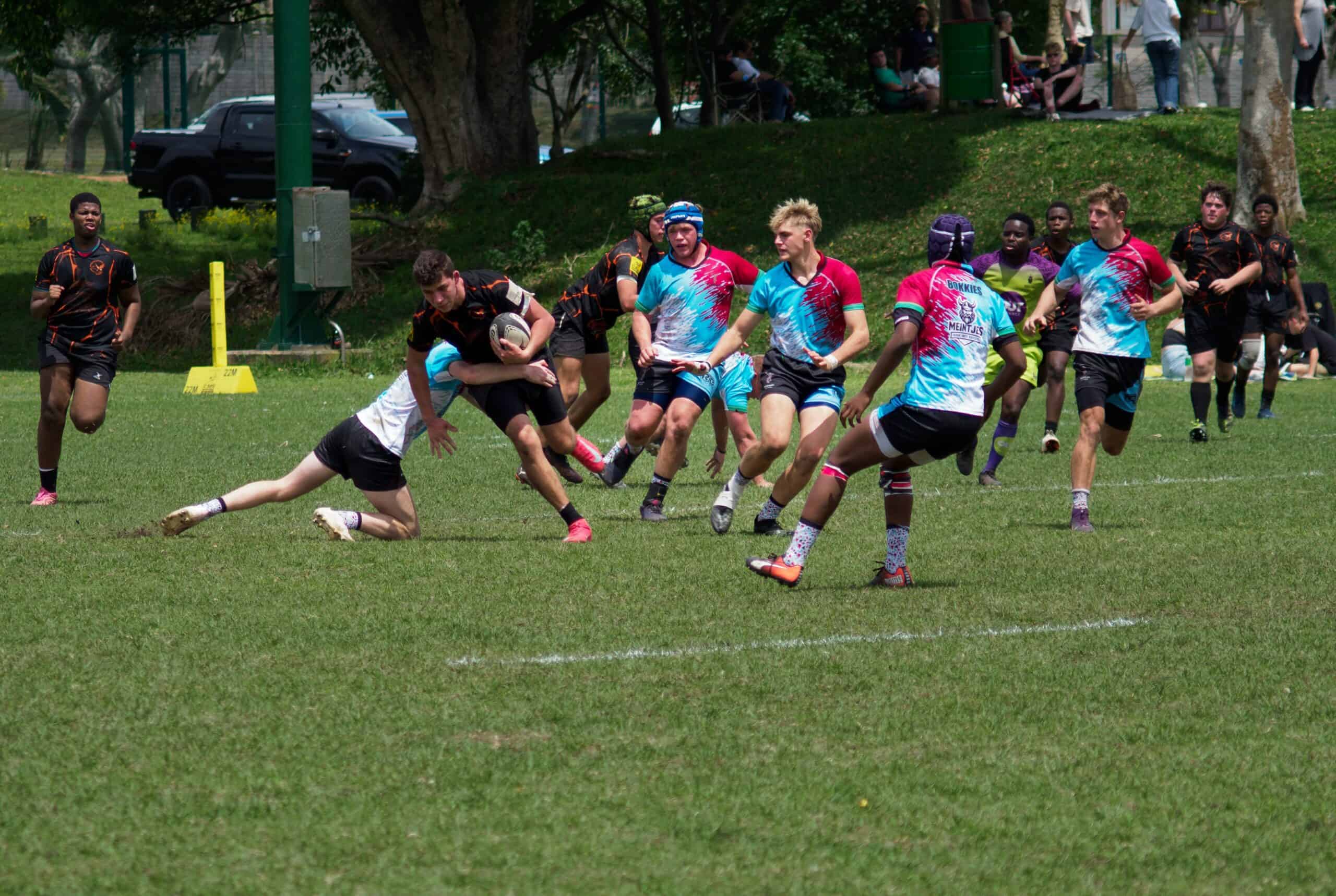 A rugby player tries to make it past a defender.