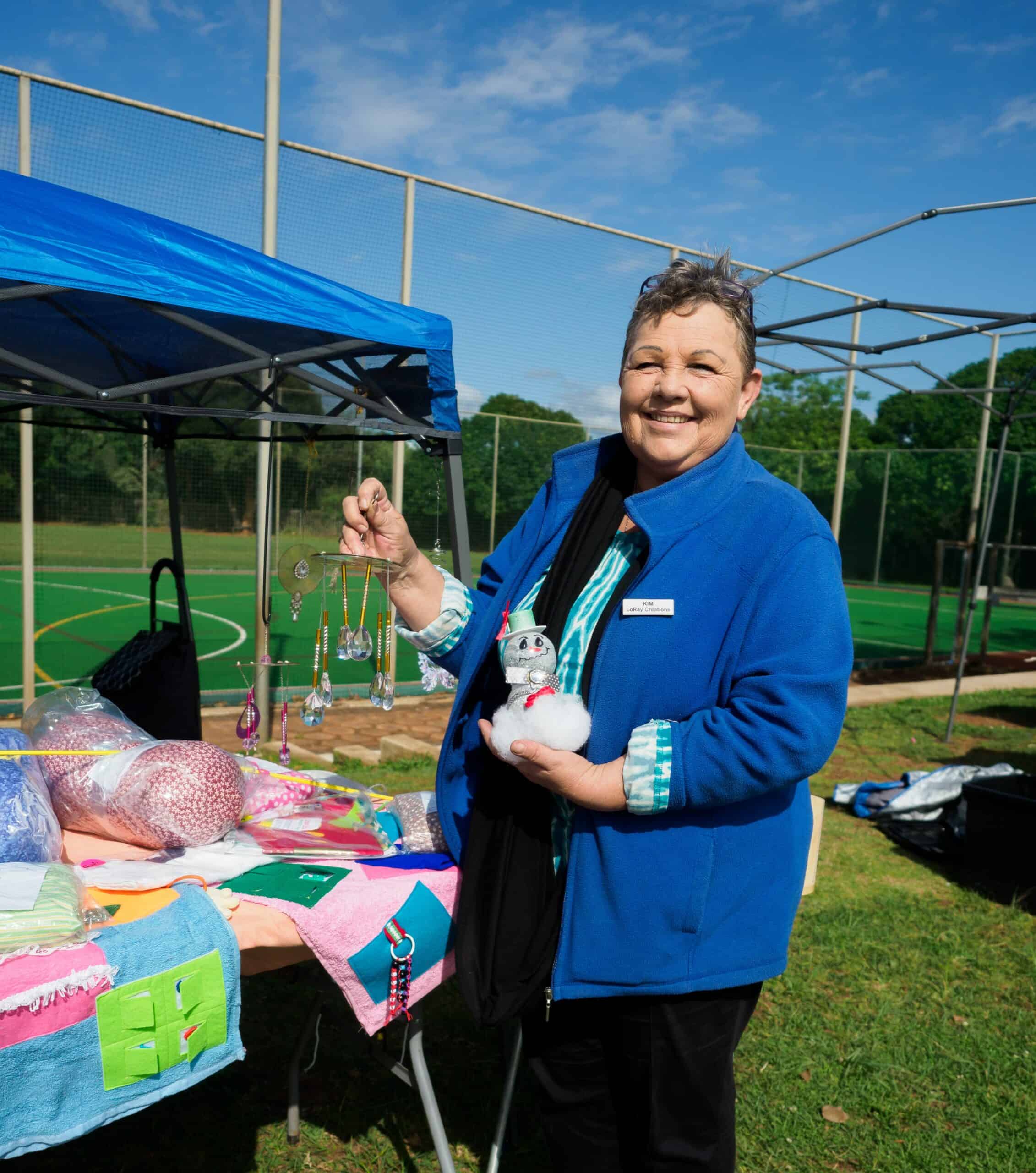 A woman showing her crocheted crafts.