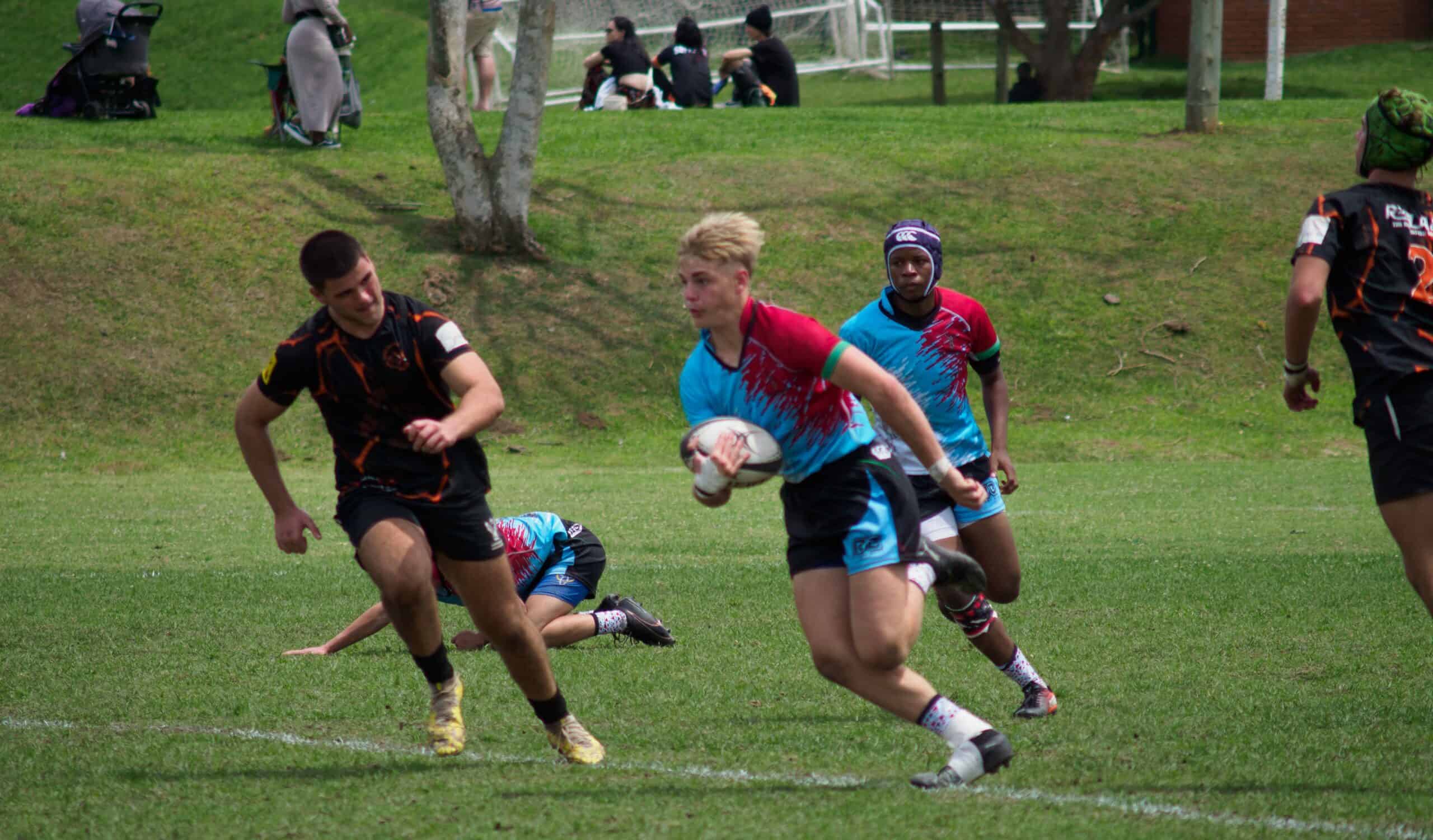 A rugby player tries to make it past a defender.