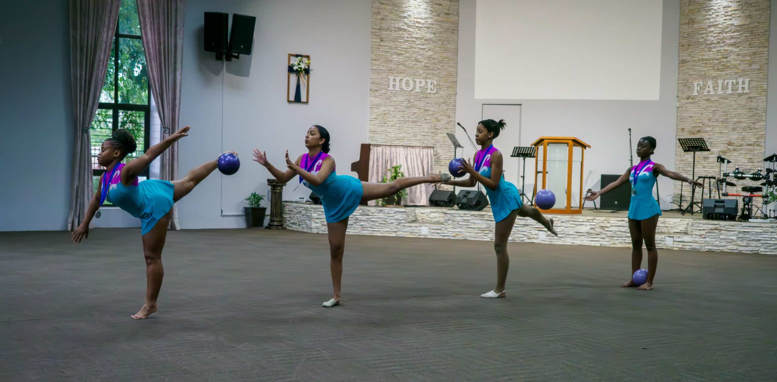 Gymnasts using balls for a routine.