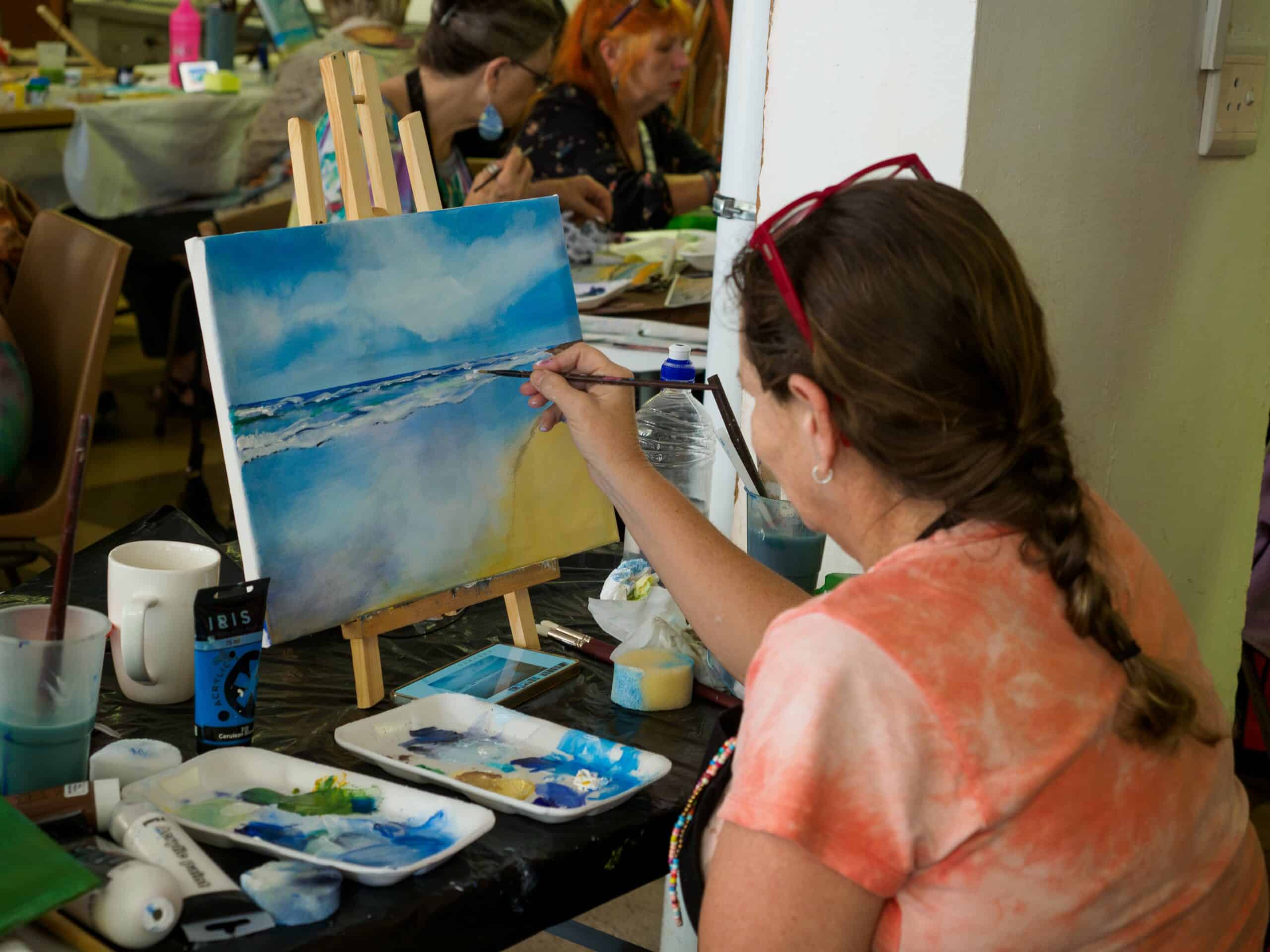 A woman painting a beach.