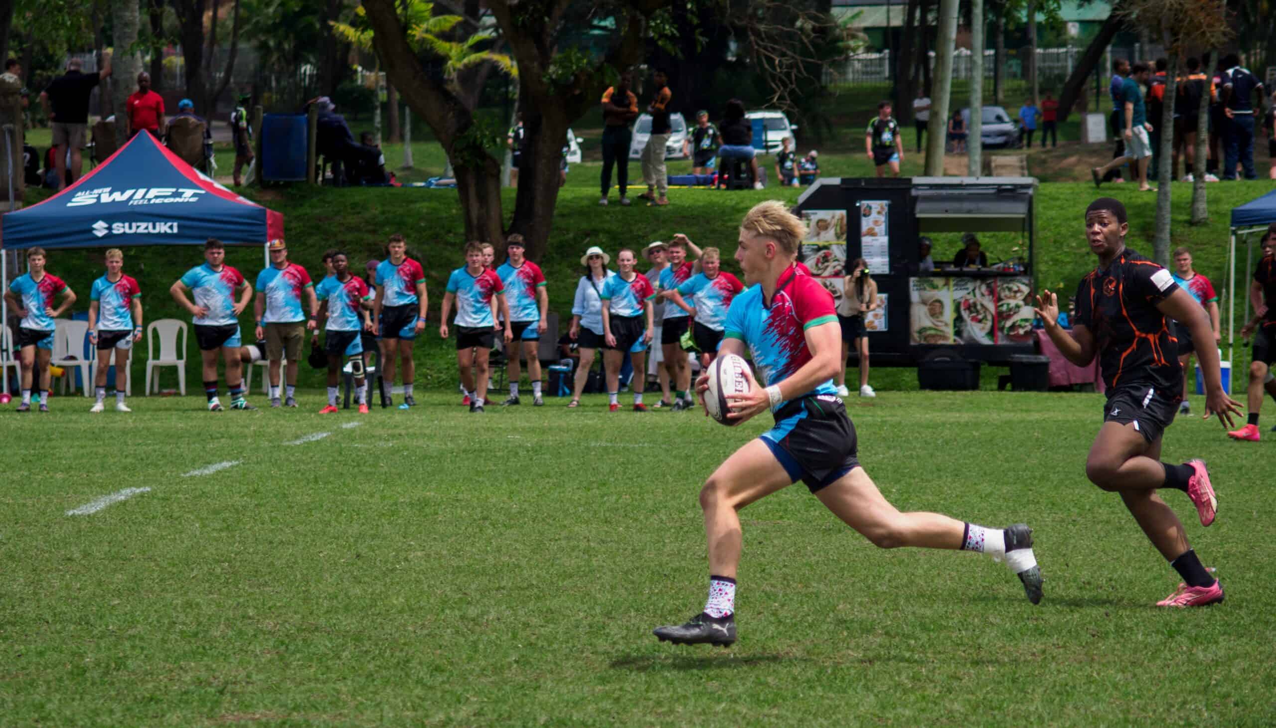 A rugby player clears all defenders as he attacks.