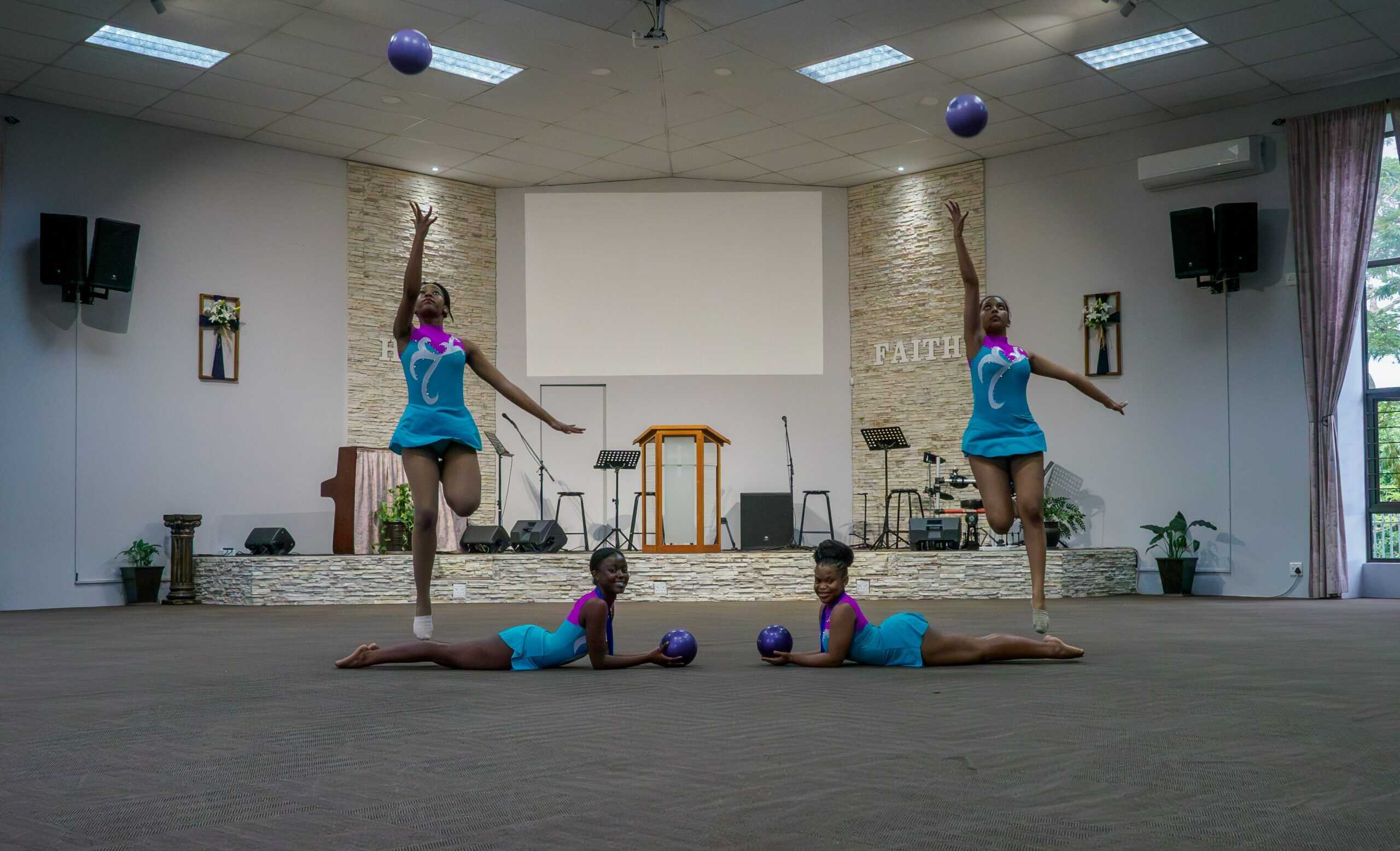 Gymnasts using balls for a routine.