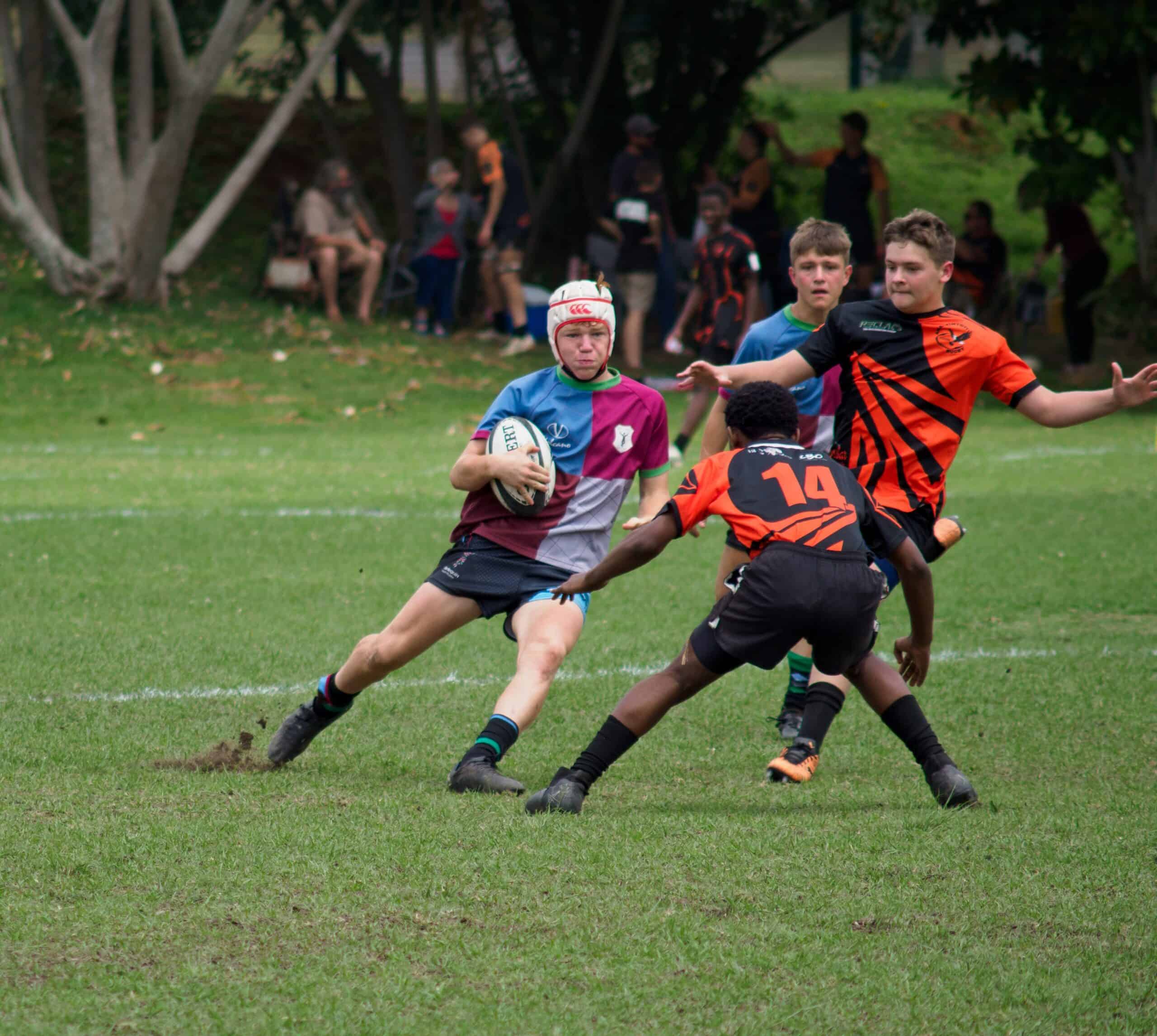 A rugby player tries to make it past a defender.