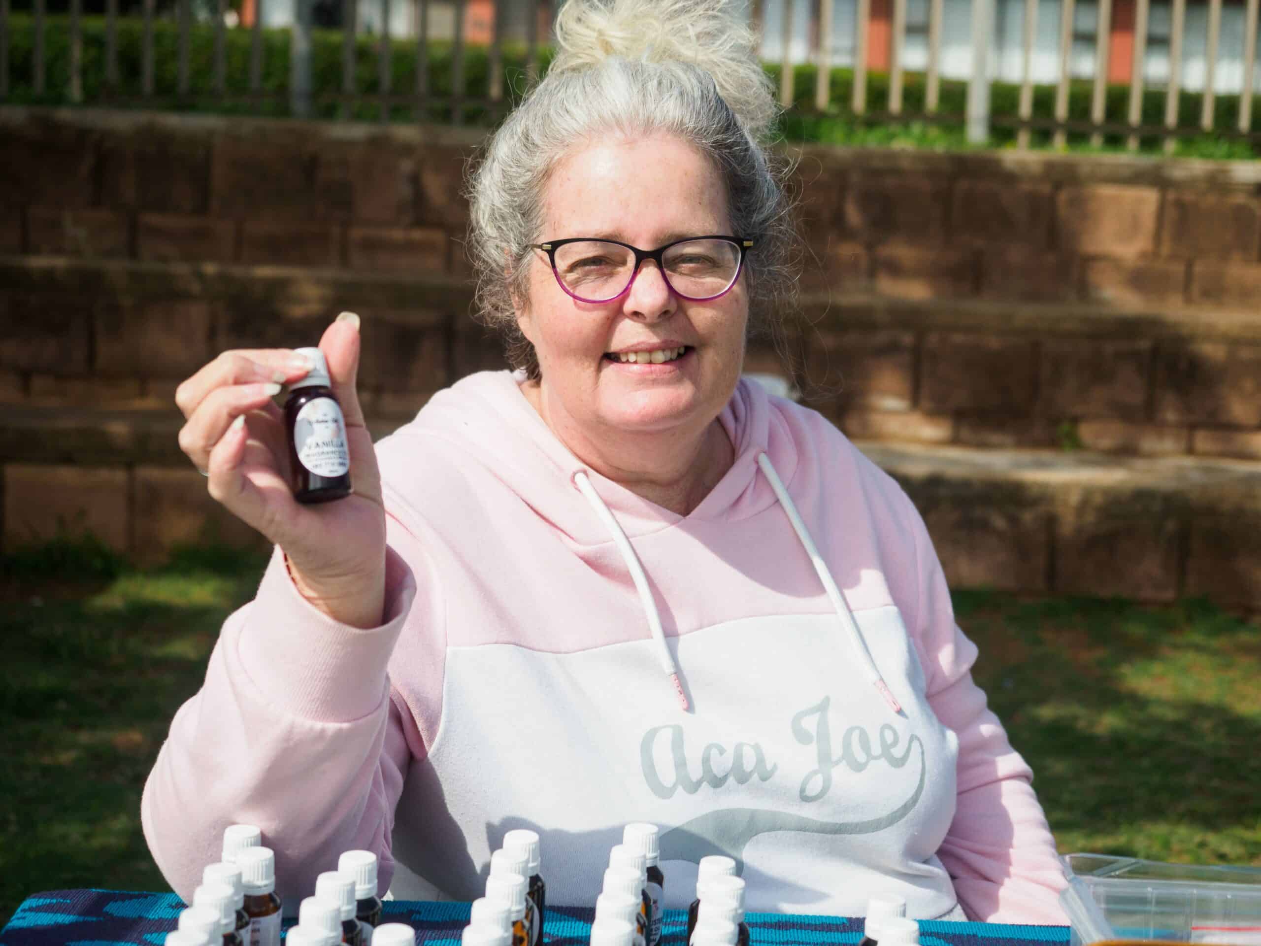 A woman holding a bottle of scented oil.