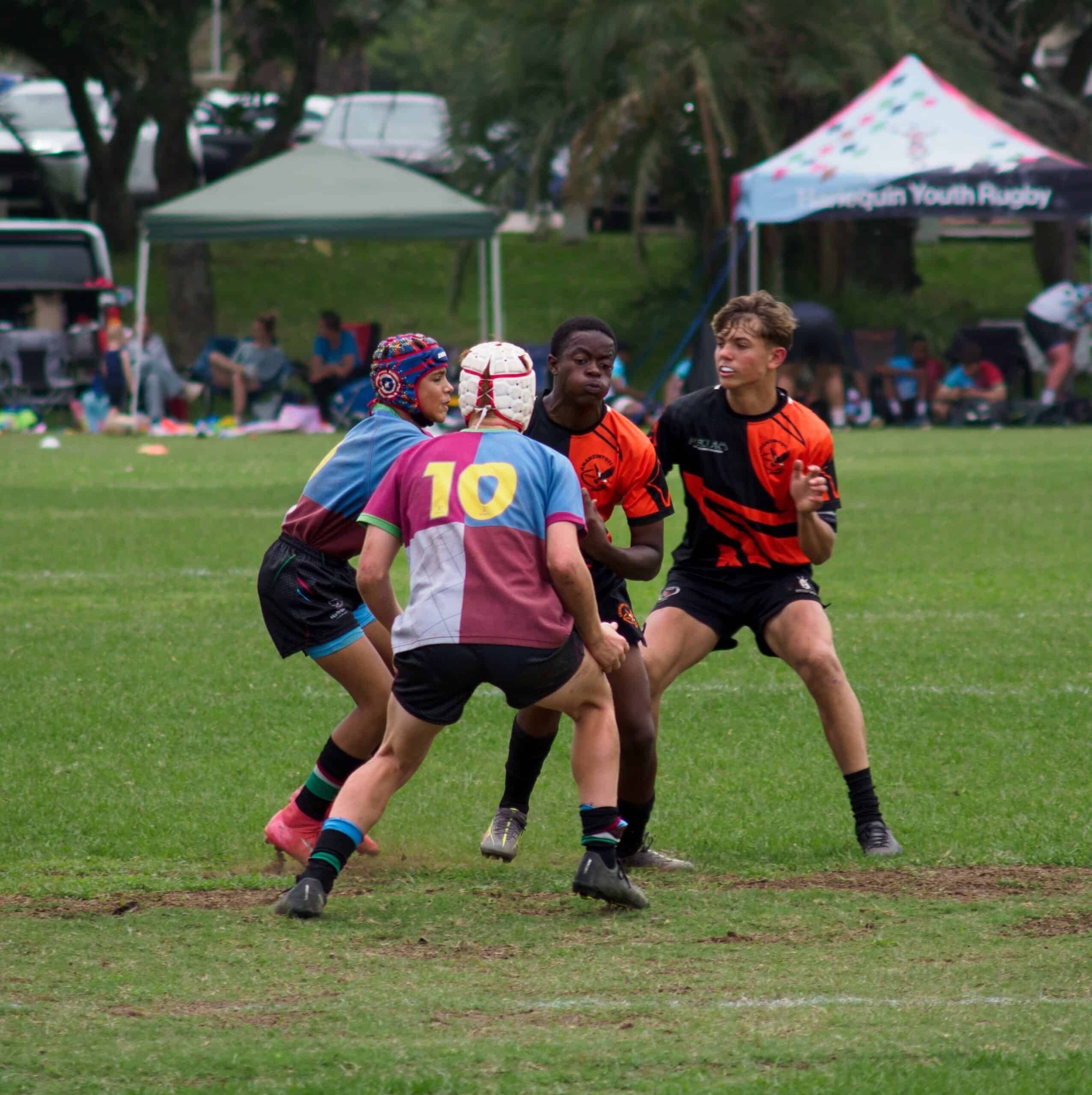 A rugby player tries to make it past a defender.
