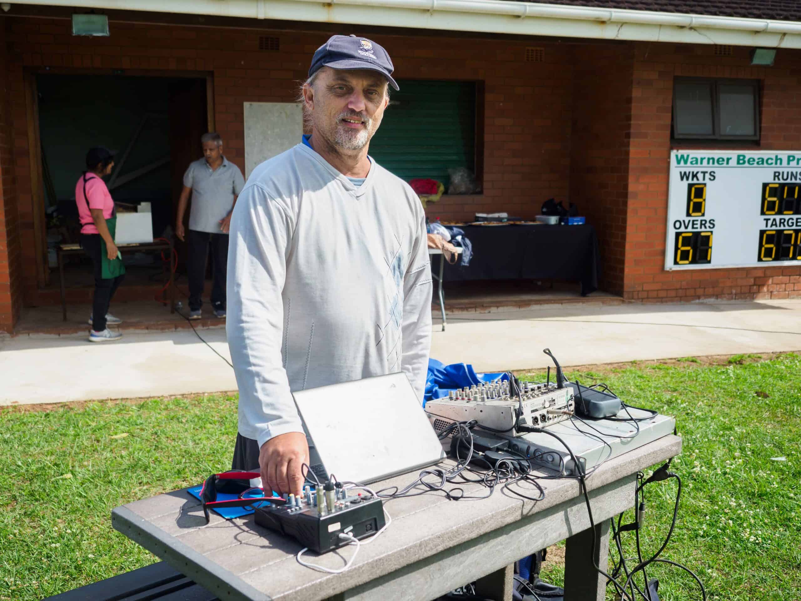 A man stands at his DJ booth.