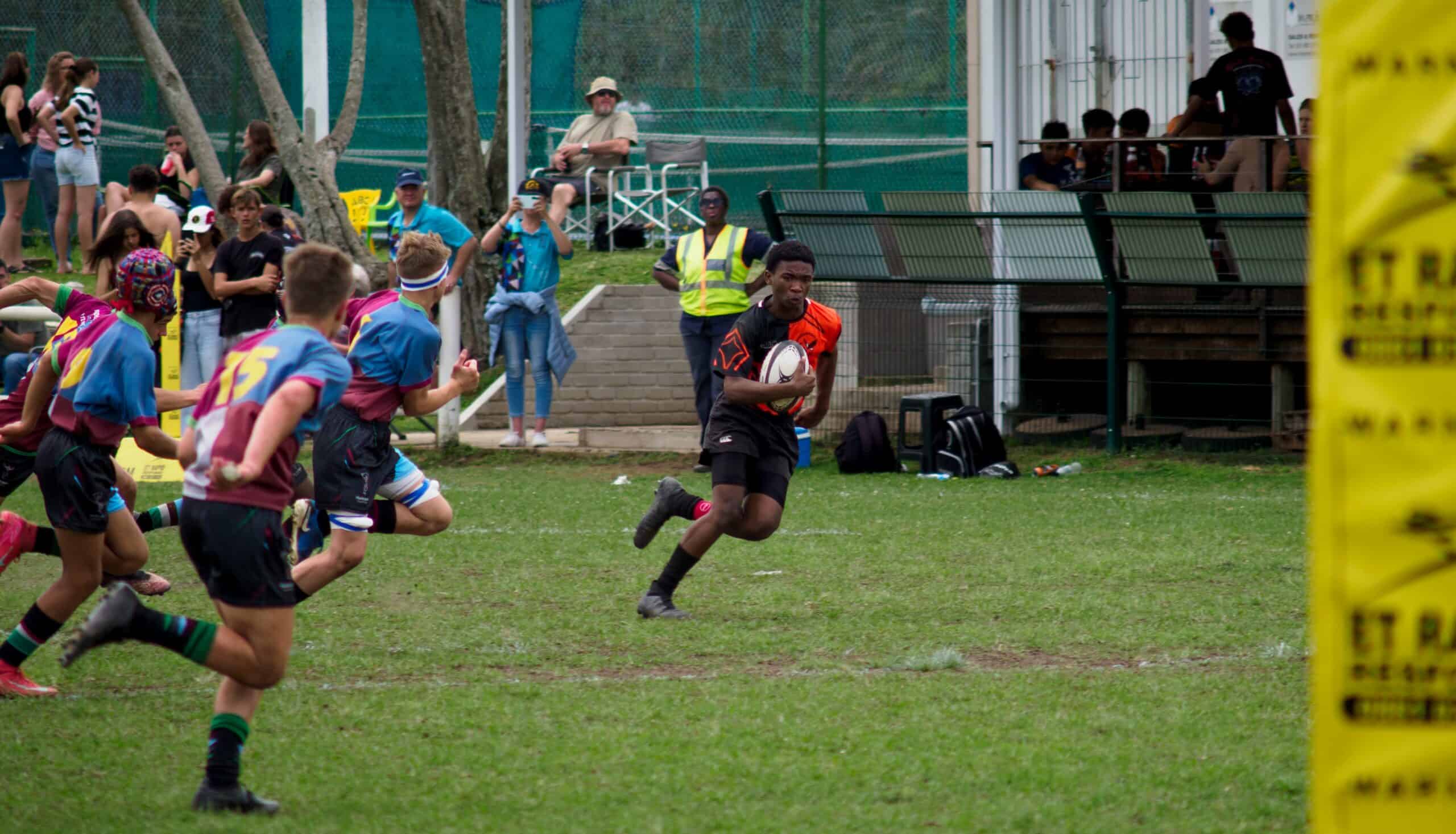 A rugby player clears all defenders as he attacks.