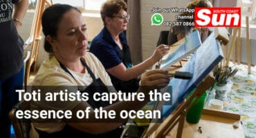 Two women painting a beach.