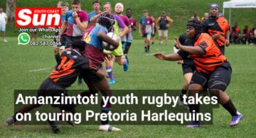 A rugby player tackling another rugby player. A defender is about to tackle as well.