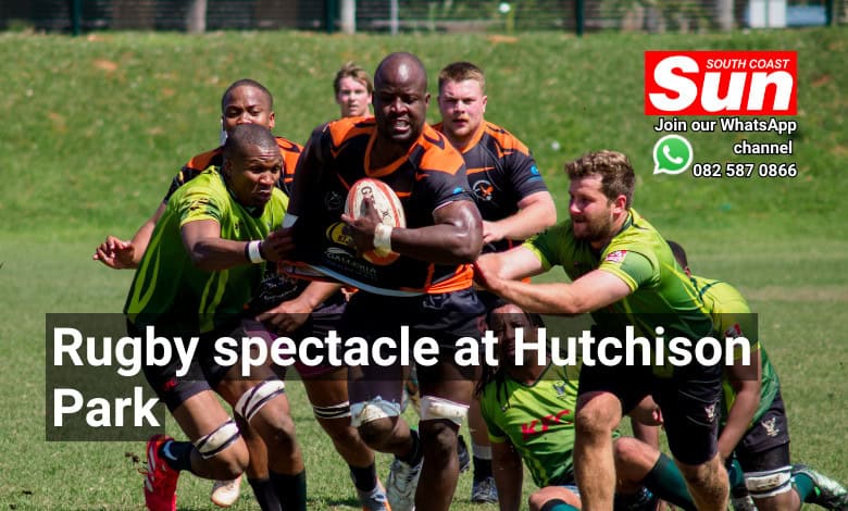 A rugby player fending off multiple rugby players of the other team.