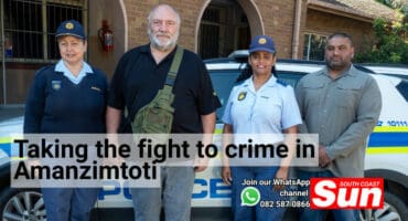 A group picture in front of a police car with two female police officers.