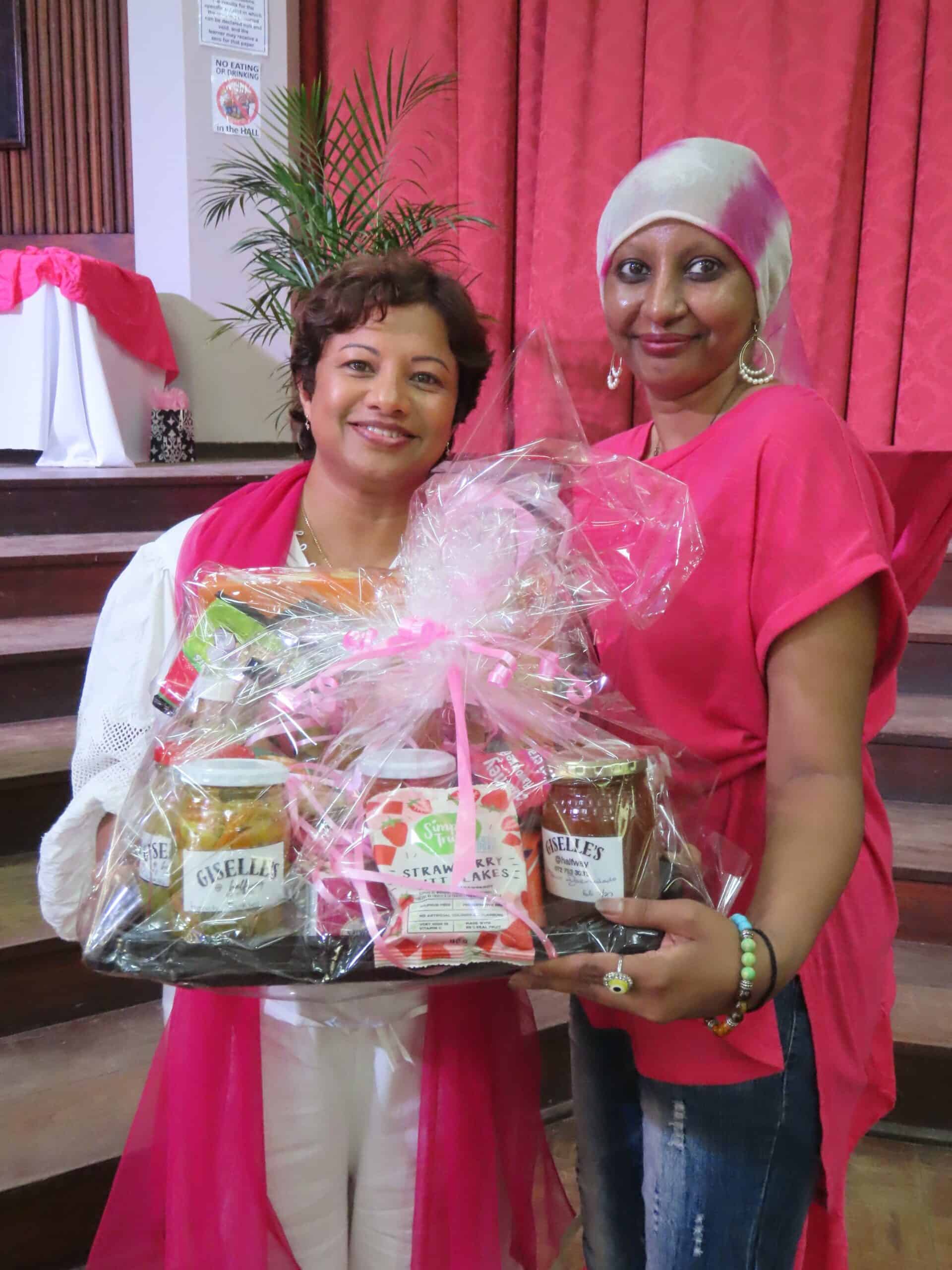 A woman handing over a gift bag to another woman