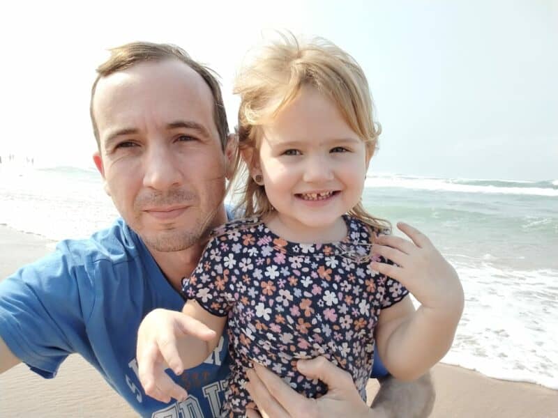 A father and his daughter at the beach. 