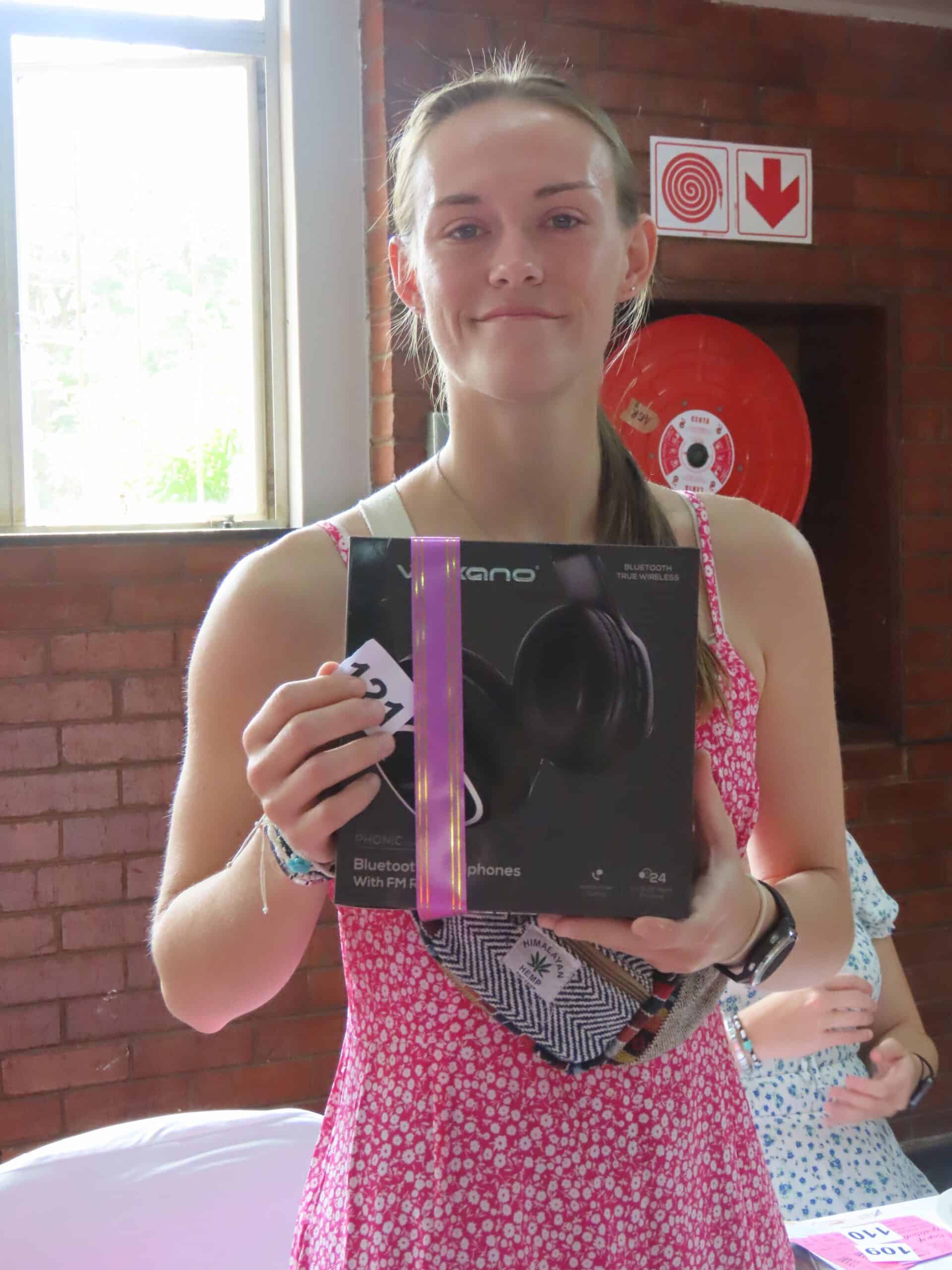 A woman holding a box of headphones.