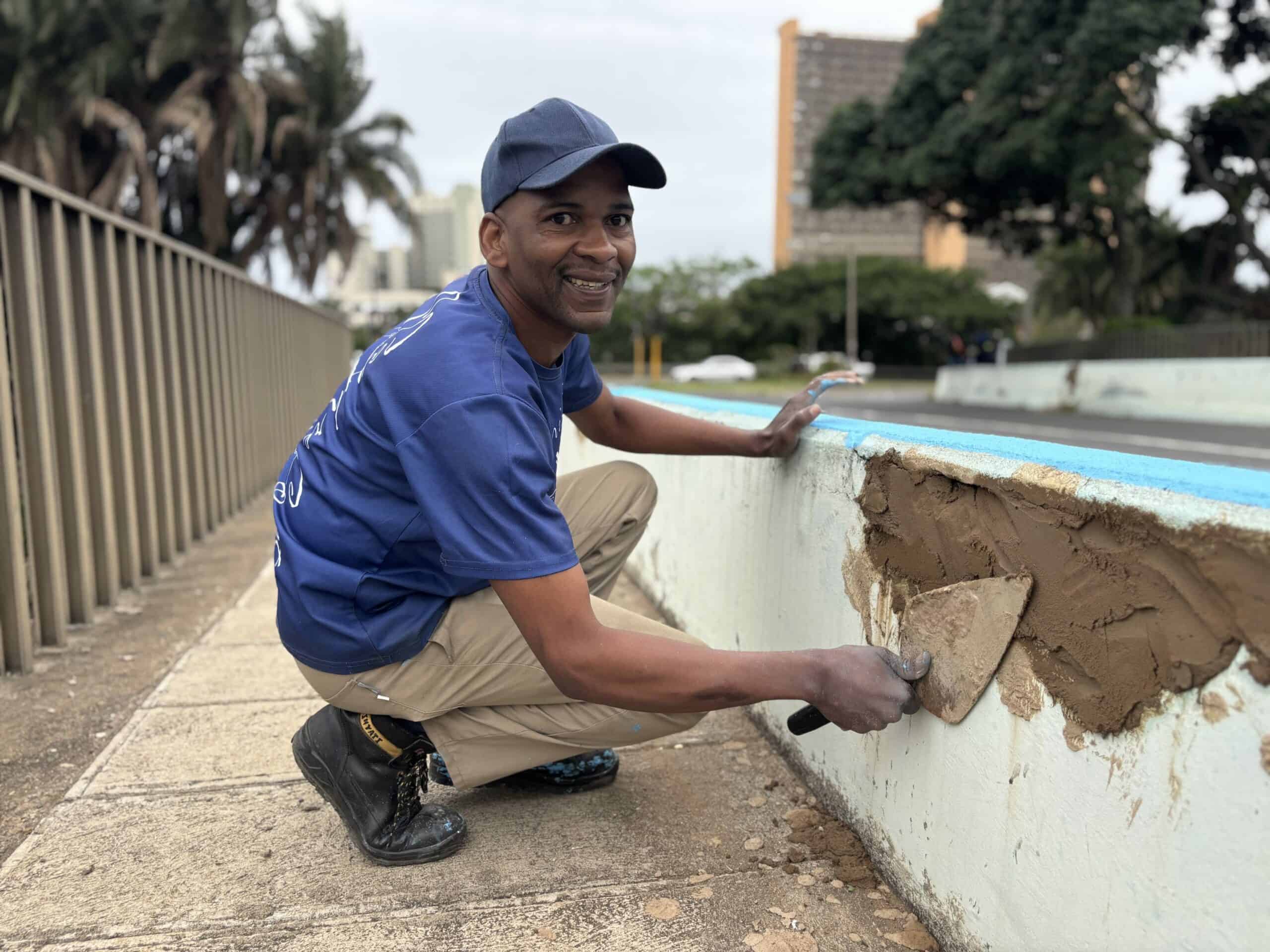 A man working on restoring a bridge. 
