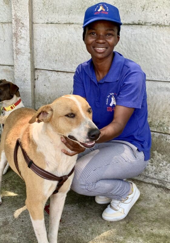 A woman playing with two dogs.