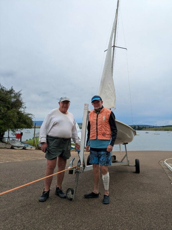 Two sailors in front of their yacht. 