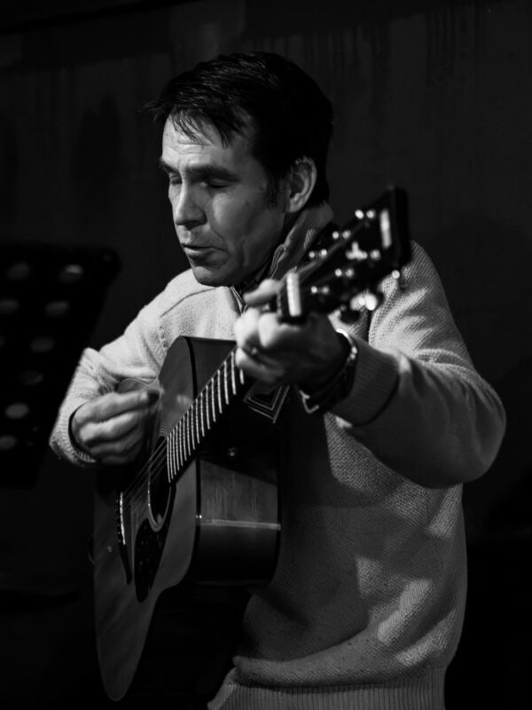 A man playing the guitar and singing.