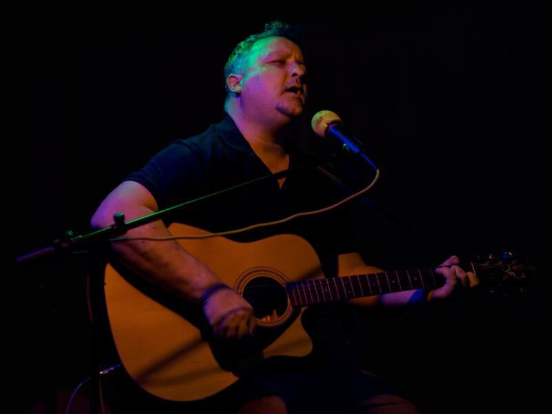 A man playing guitar and singing.