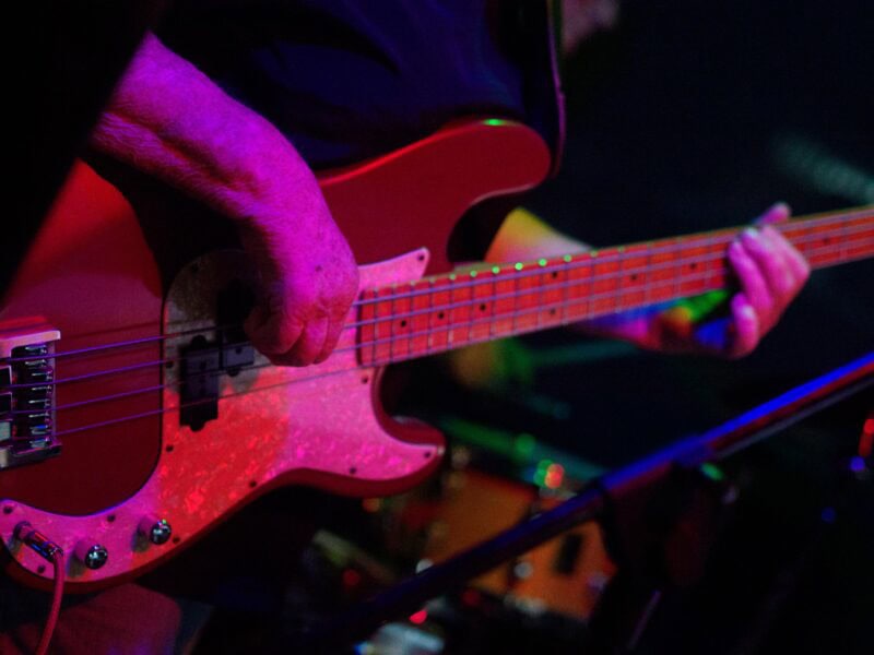 A close up of a woman playing bass.