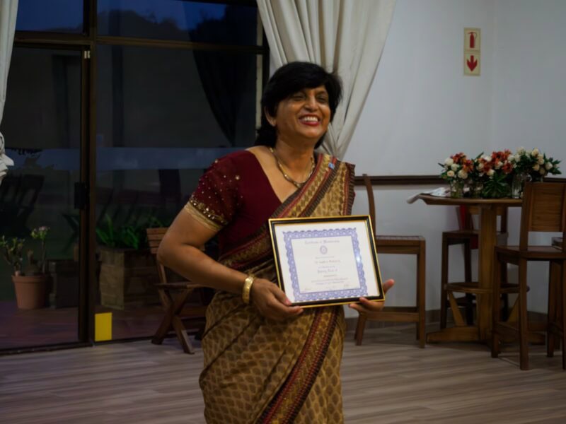 A woman holding a certificate, smiling.