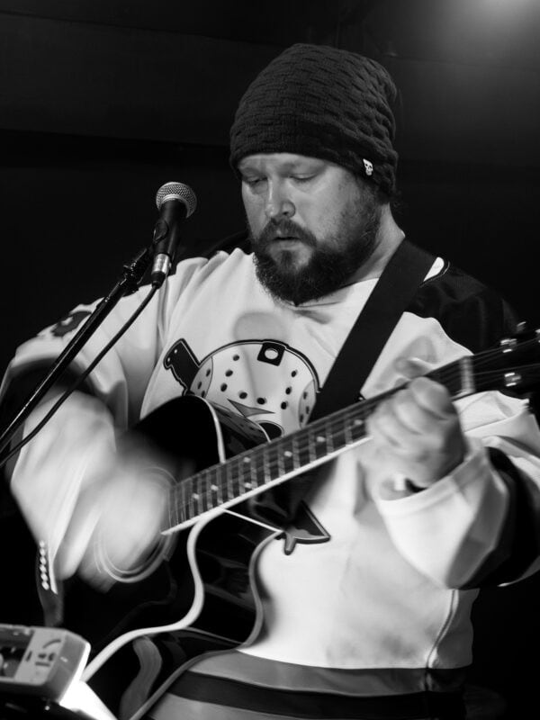 A man playing the guitar and singing.