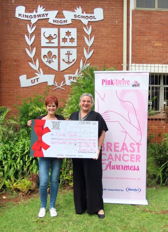 A woman handing over a large cheque to another woman.