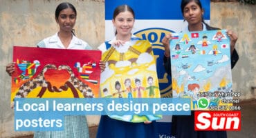 School children holding up peace posters they designed.